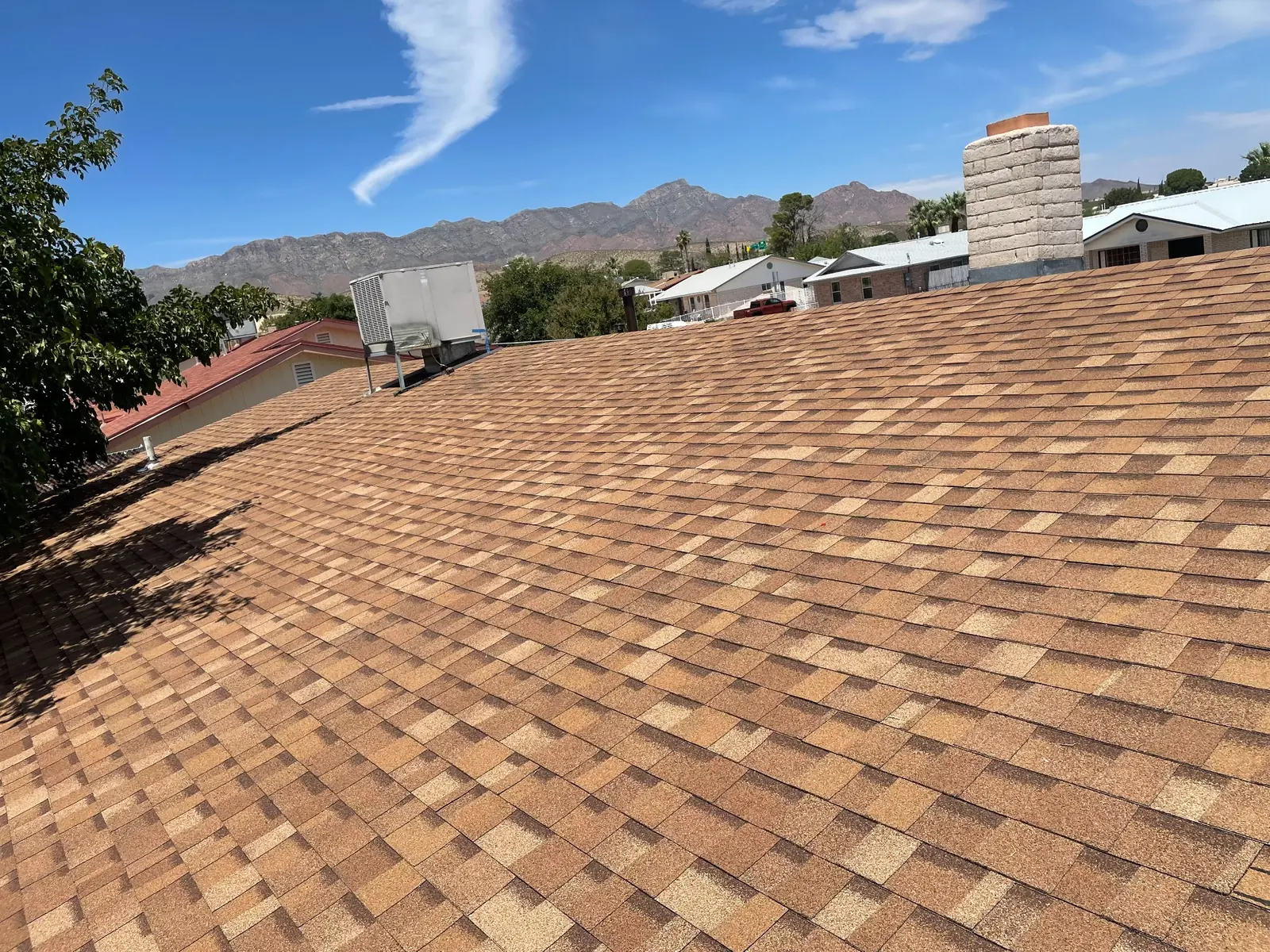 Brown architectural shingle roof with the Franklin Mountains in El Paso